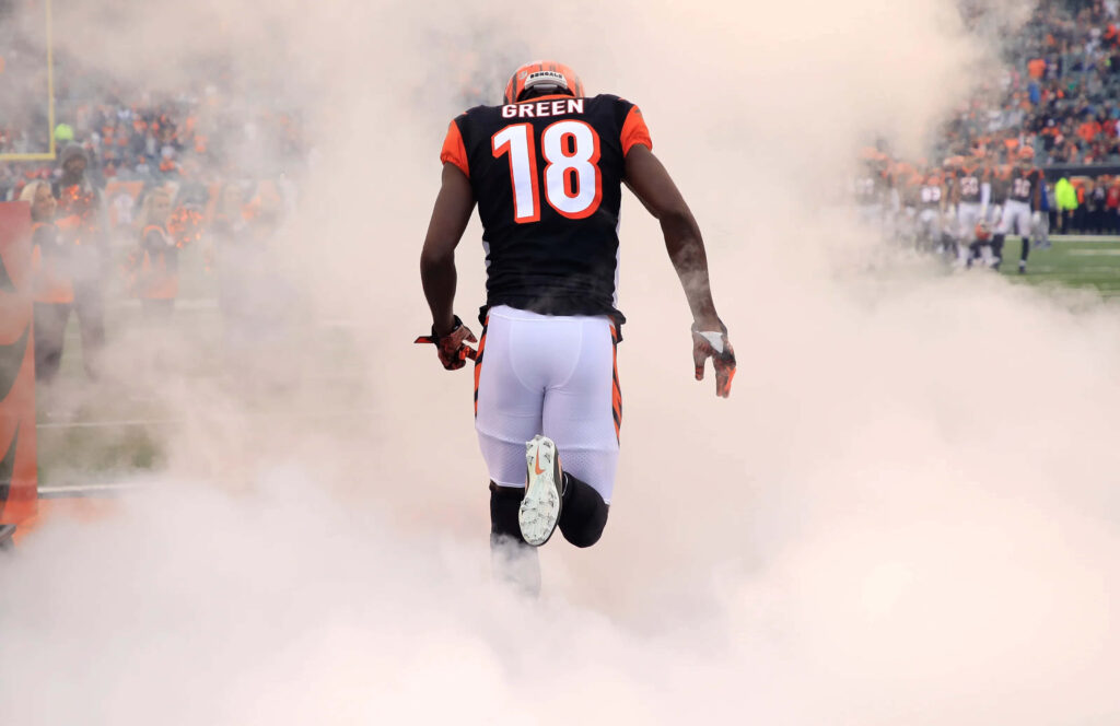 A.J. Green entering field in number 18 Bengals jersey with smoky electrifying game day background Wallpaper