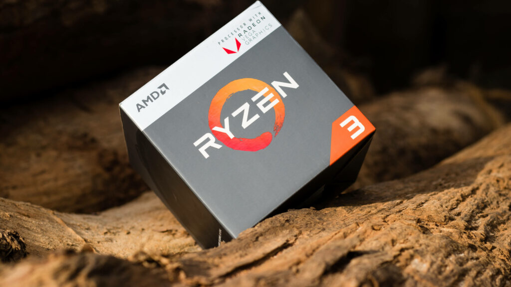 AMD Ryzen 3 processor box on natural wooden surface high resolution tech wallpaper background