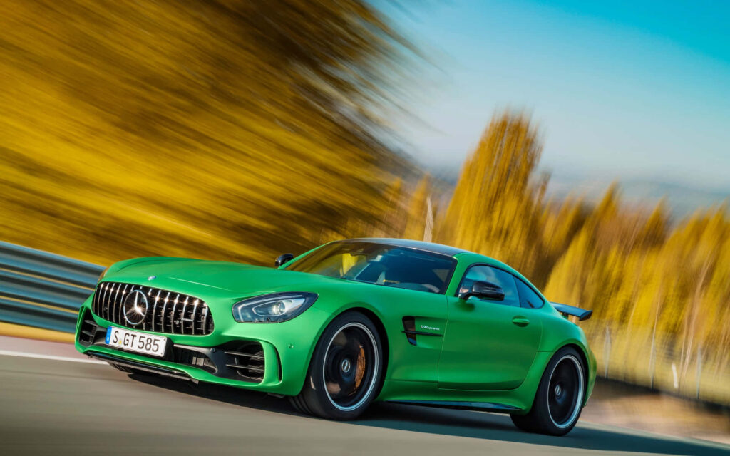 AMG GT-R Green Hell Mango speeding on road with dynamic blurred background showcasing power Wallpaper
