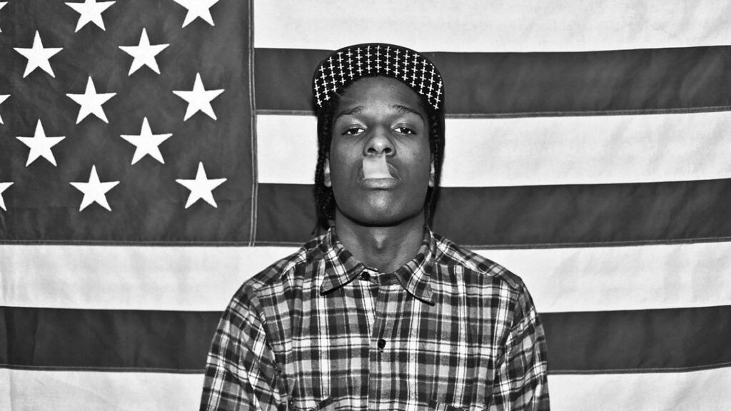 A$AP Rocky standing before American flag hip hop wallpaper cool rebellious style background