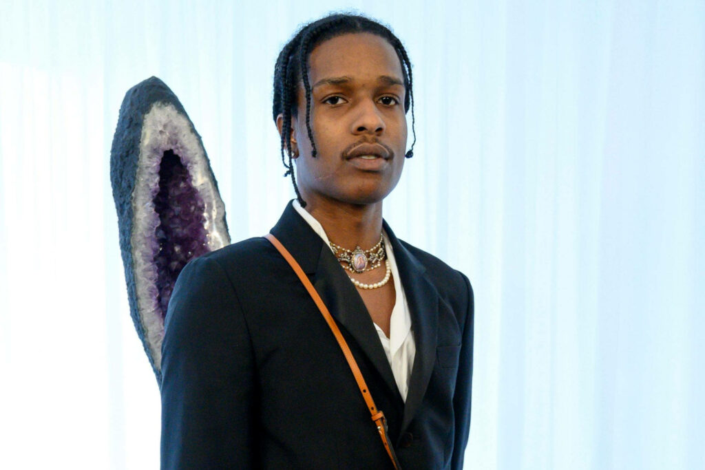 A$AP Rocky in black suit with amethyst geode background showcasing unique fashion style Wallpaper