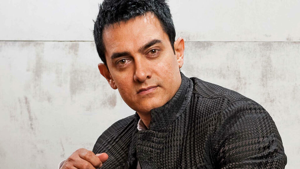 Aamir Khan serious expression dark textured jacket neutral background intense thoughtful wallpaper
