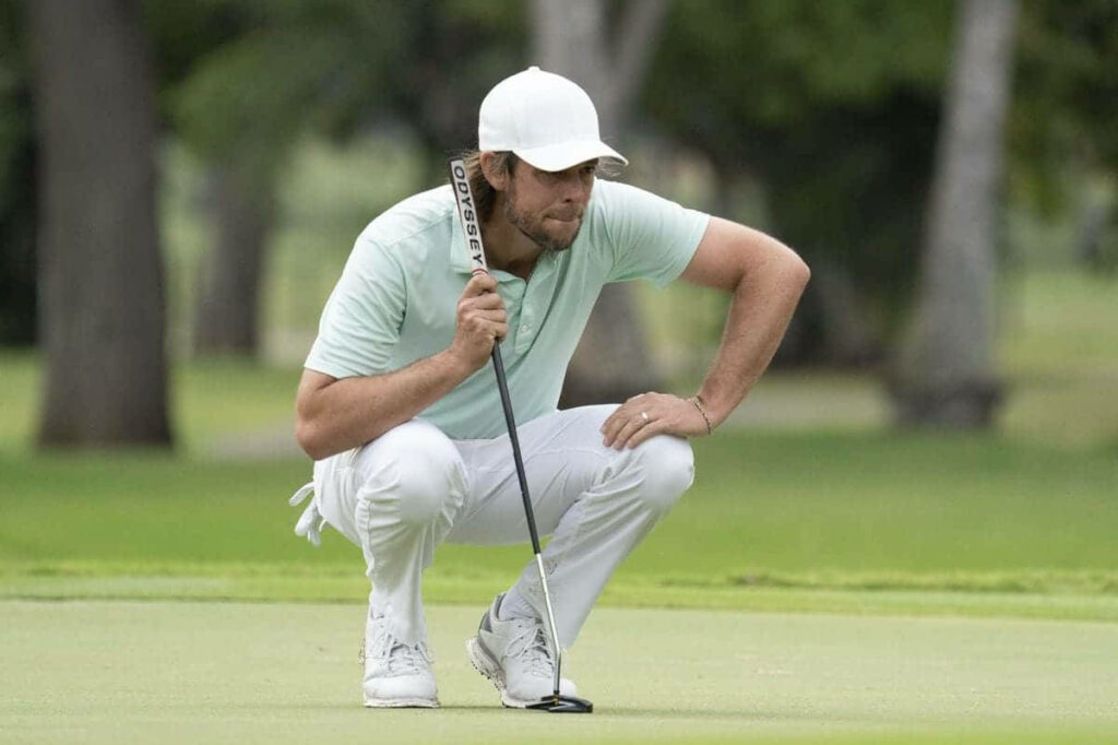 Aaron Baddeley concentrating on a putt on vibrant green PGA Tour golf course wallpaper background