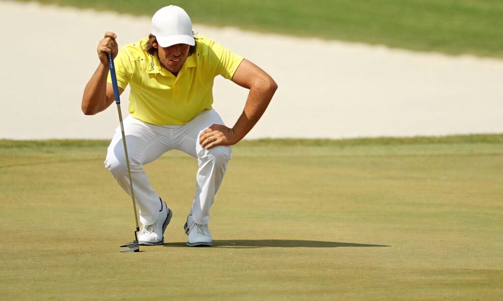 Aaron Baddeley in yellow shirt and white cap focusing on golf course professional golfer wallpaper