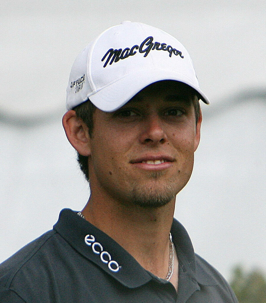 Golfer Aaron Baddeley focused in golf cap and polo shirt professional demeanor wallpaper background