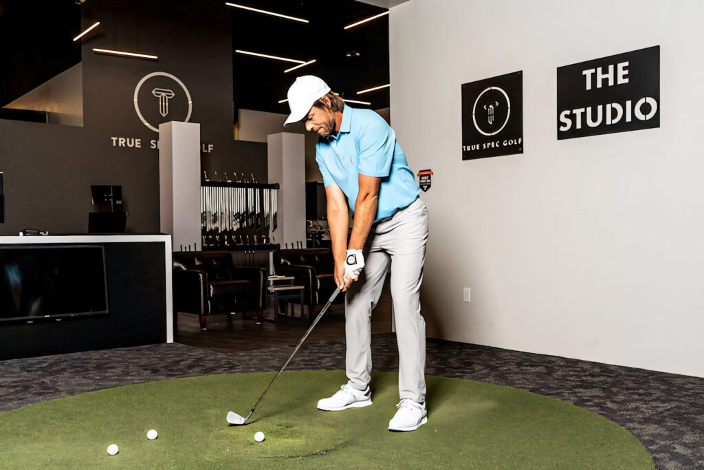Aaron Baddeley practicing golf swing indoors at True Spec Golf studio with pro equipment Wallpaper