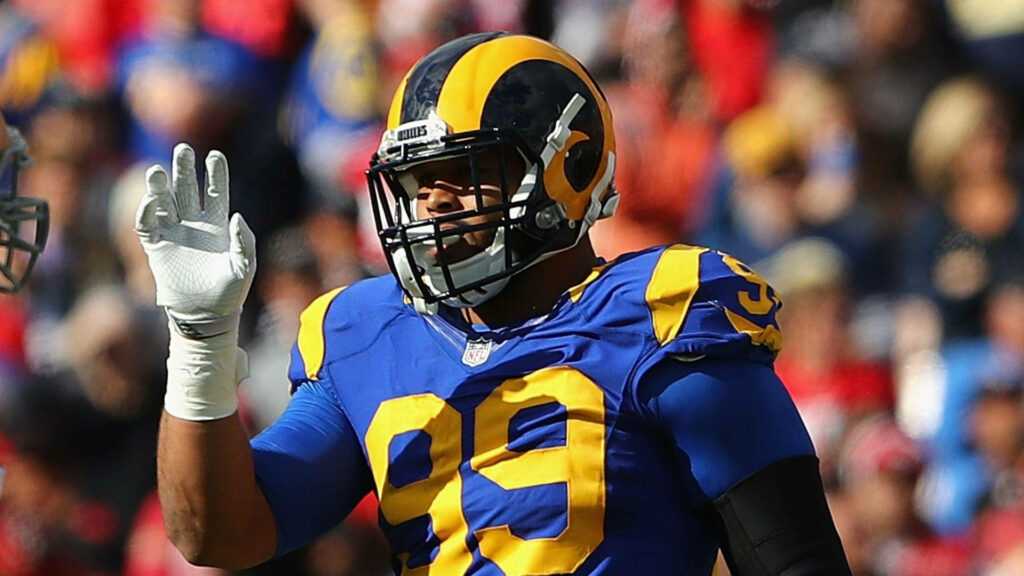 Aaron Donald wearing Los Angeles Rams blue jersey showing intense focus on football field background Wallpaper