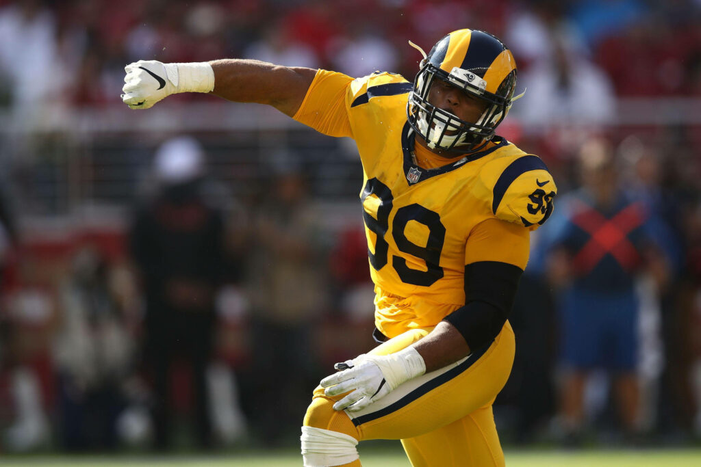 Aaron Donald in yellow Los Angeles Rams jersey showing power and intensity on the football field Wallpaper