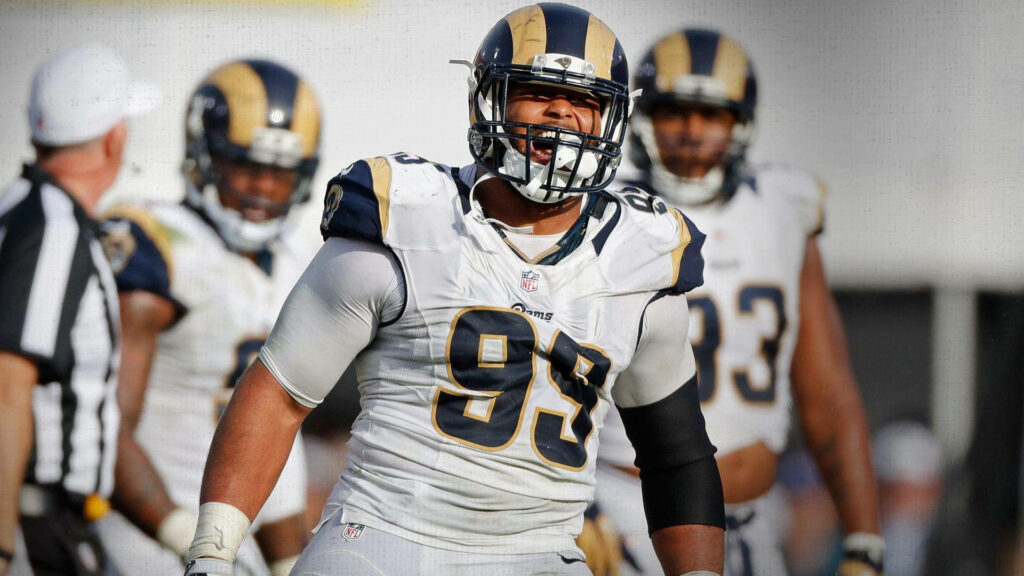 Aaron Donald in white number 99 jersey showing power and intensity on football field wallpaper