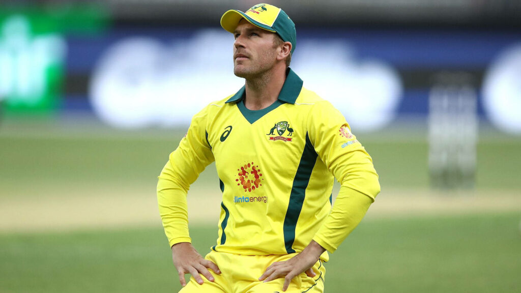 Australian cricketer Aaron Finch in yellow uniform focused on field during cricket match wallpaper