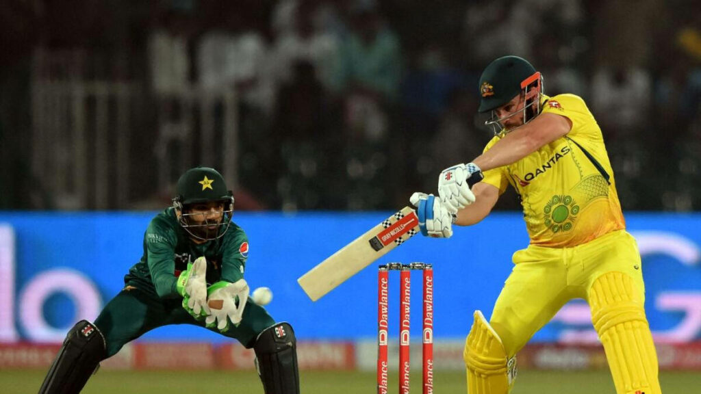 Aaron Finch playing a powerful cricket shot against Pakistan with focused wicketkeeper behind Wallpaper