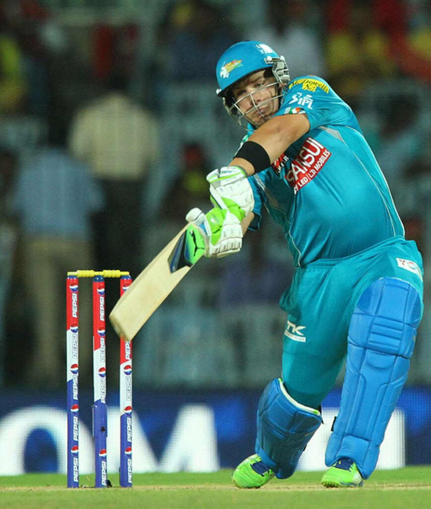 Aaron Finch in turquoise cricket uniform powerfully striking ball during dynamic match play Wallpaper