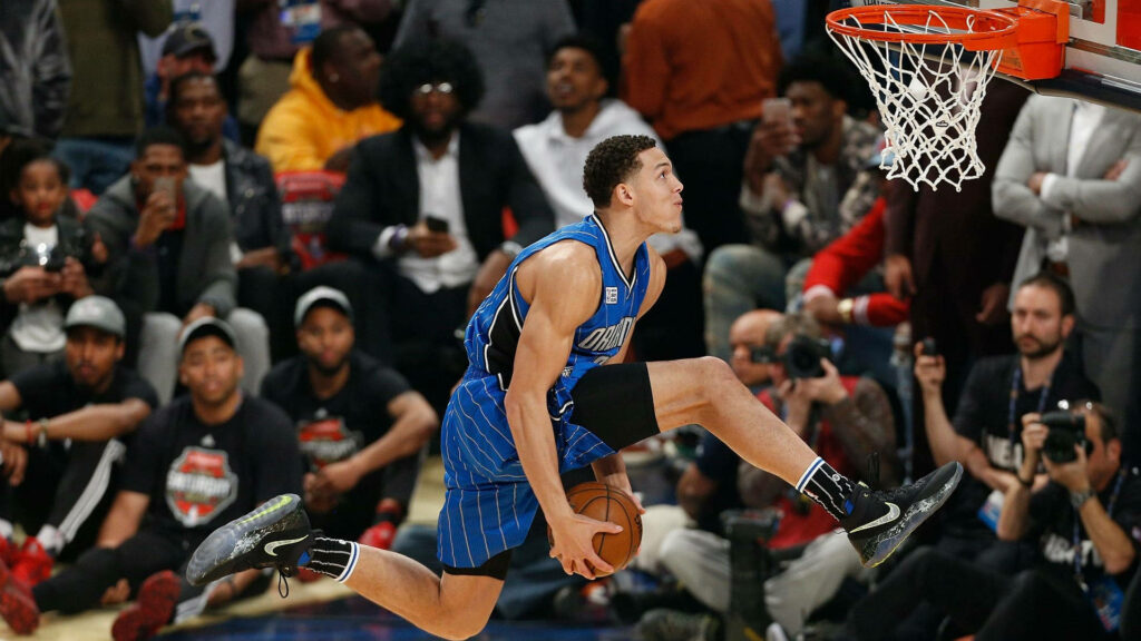 Aaron Gordon performing a double clutch dunk in NBA Slam Dunk Contest with excited crowd Wallpaper