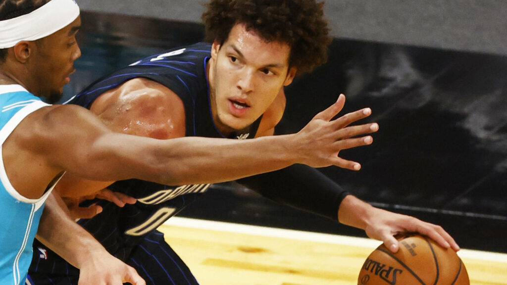 Aaron Gordon driving past defender basketball court intense athleticism dynamic wallpaper background