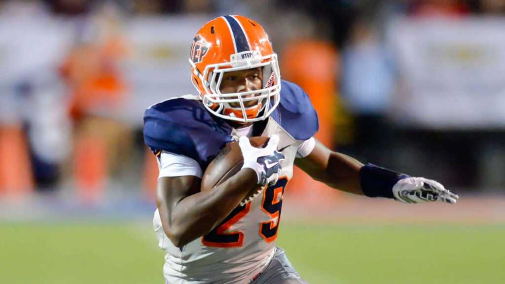 Aaron Jones running down football field showing determination and athleticism in game action Wallpaper