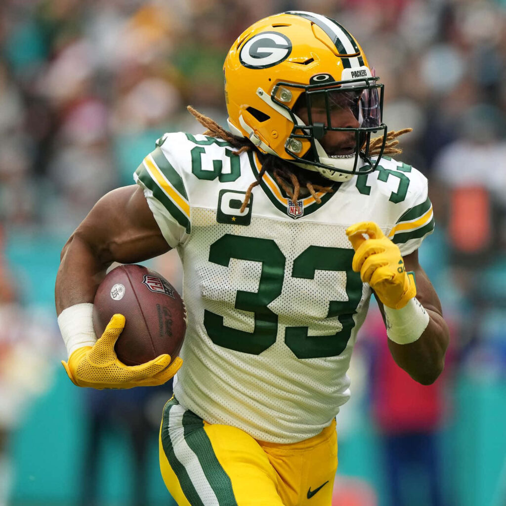 Aaron Jones Green Bay Packers running strong with football during intense NFL game action wallpaper
