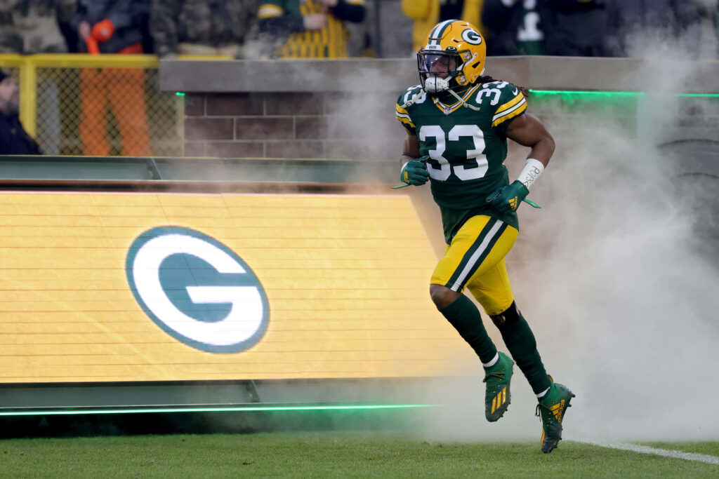 Aaron Jones Green Bay Packers charging on field full uniform game day energy smoke background wallpaper