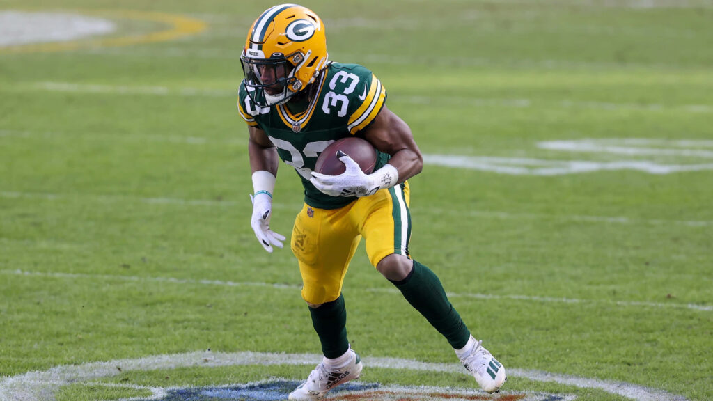 Aaron Jones Green Bay Packers running back charging forward focused during NFL game action wallpaper