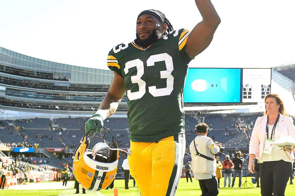 Aaron Jones Green Bay Packers running with football during home game dynamic sports wallpaper