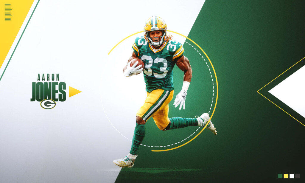 Green Bay Packers Aaron Jones sprinting with football reaching for touchdown on green yellow background Wallpaper