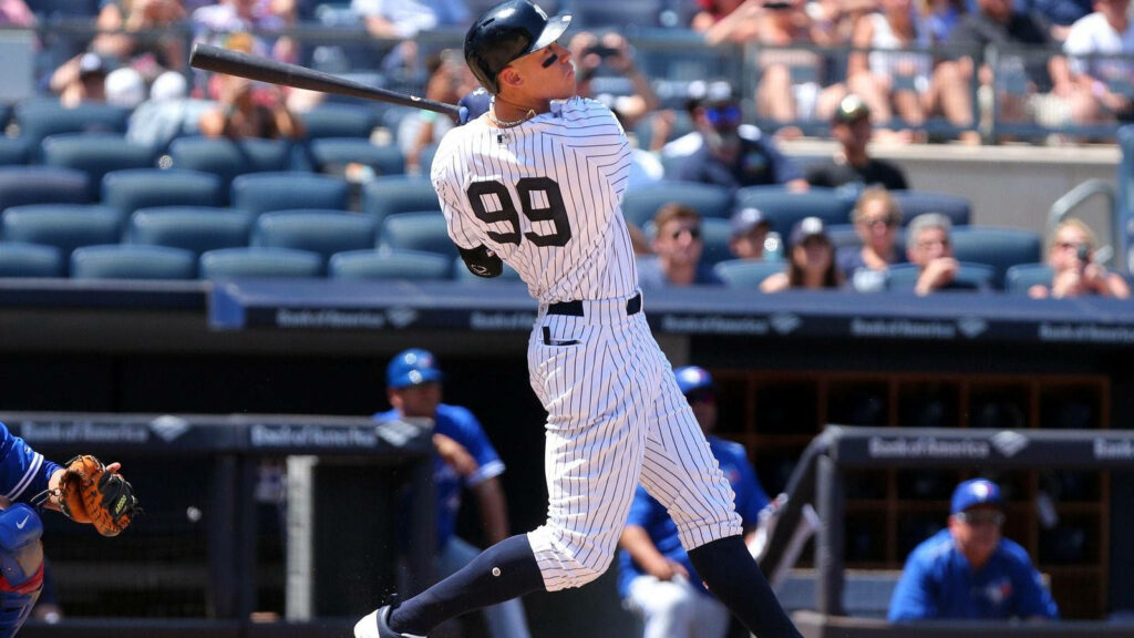 Aaron Judge mid-swing in New York Yankees uniform powerful baseball player wallpaper background