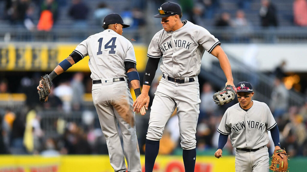 Aaron Judge celebrates victory with New York Yankees teammates on field in team uniforms wallpaper