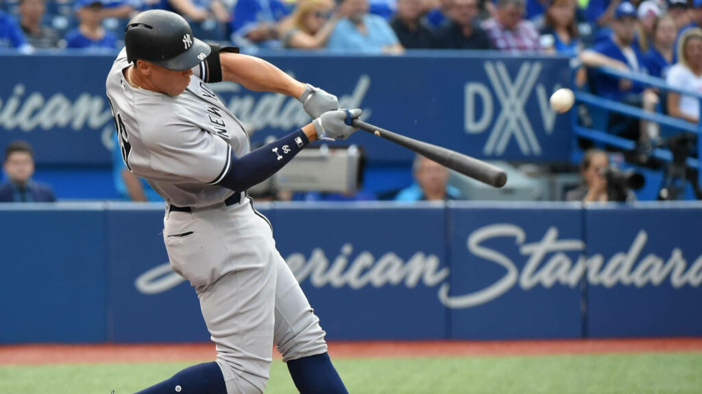Aaron Judge powerful mid swing Yankee uniform stadium background dynamic baseball wallpaper