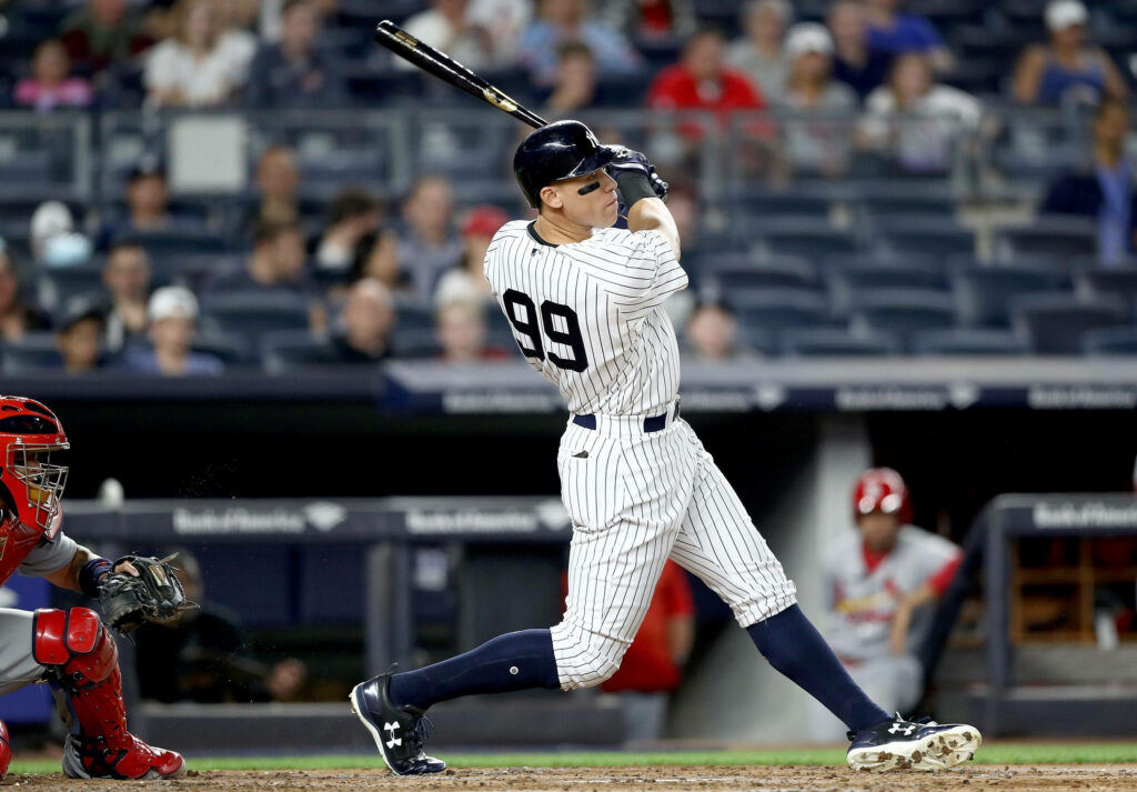 Aaron Judge mid swing powerful batting form in New York Yankees uniform during game wallpaper