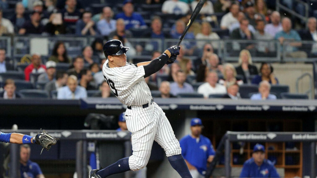 Aaron Judge powerful swing with black bat in packed stadium dynamic baseball wallpaper