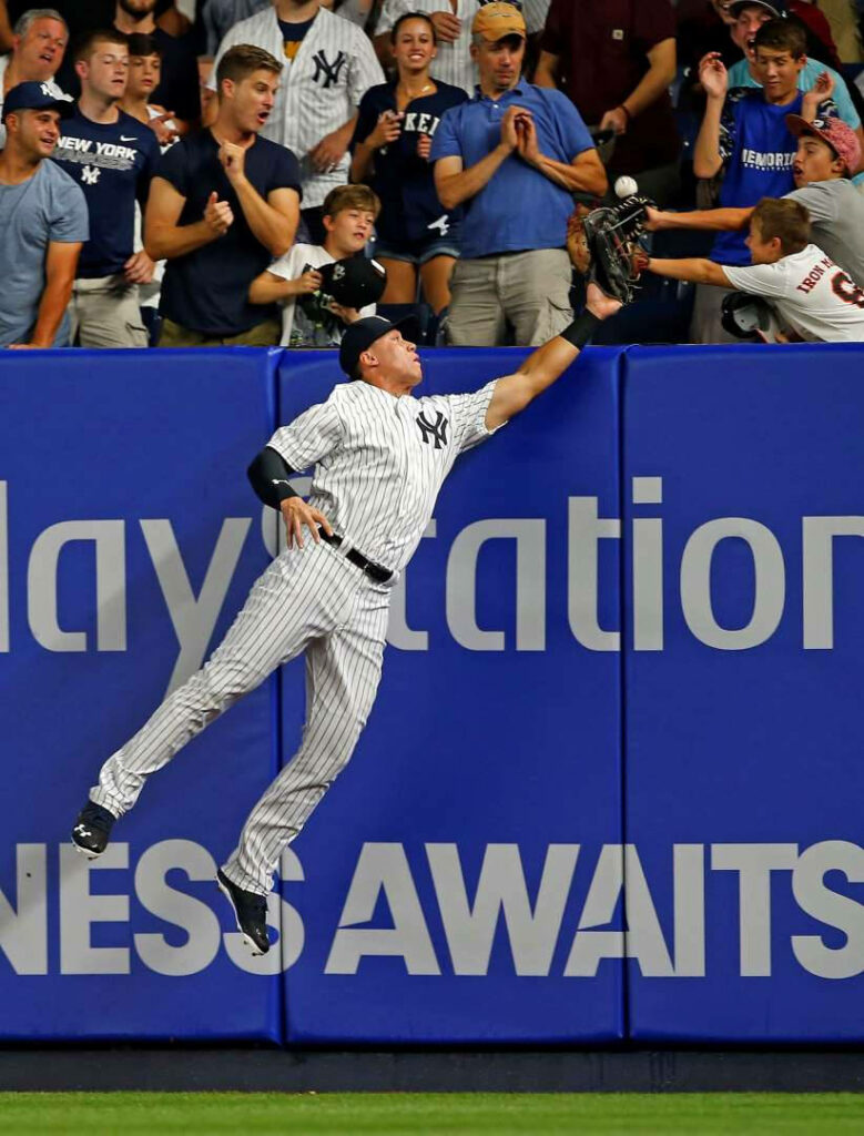 Aaron Judge leaps at outfield wall for spectacular catch thrilling baseball fans in stadium Wallpaper