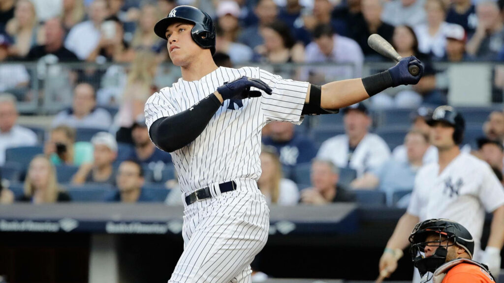 Aaron Judge New York Yankees powerful swing during baseball game with cheering fans background Wallpaper