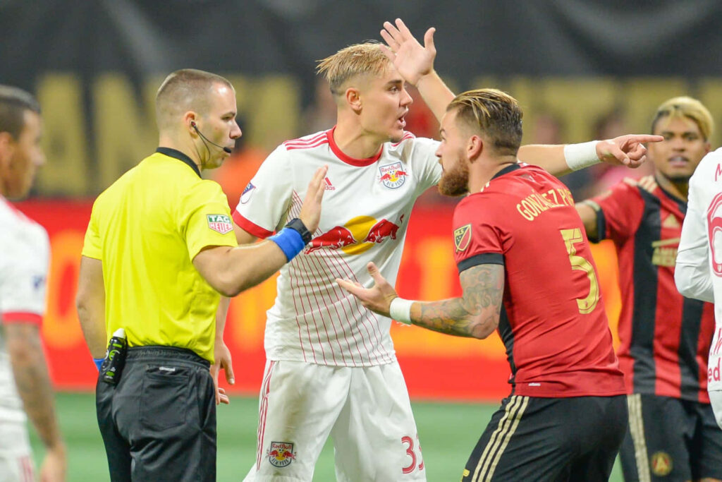 Aaron Long and Leandro González Pirez clash fiercely in intense soccer match action wallpaper background