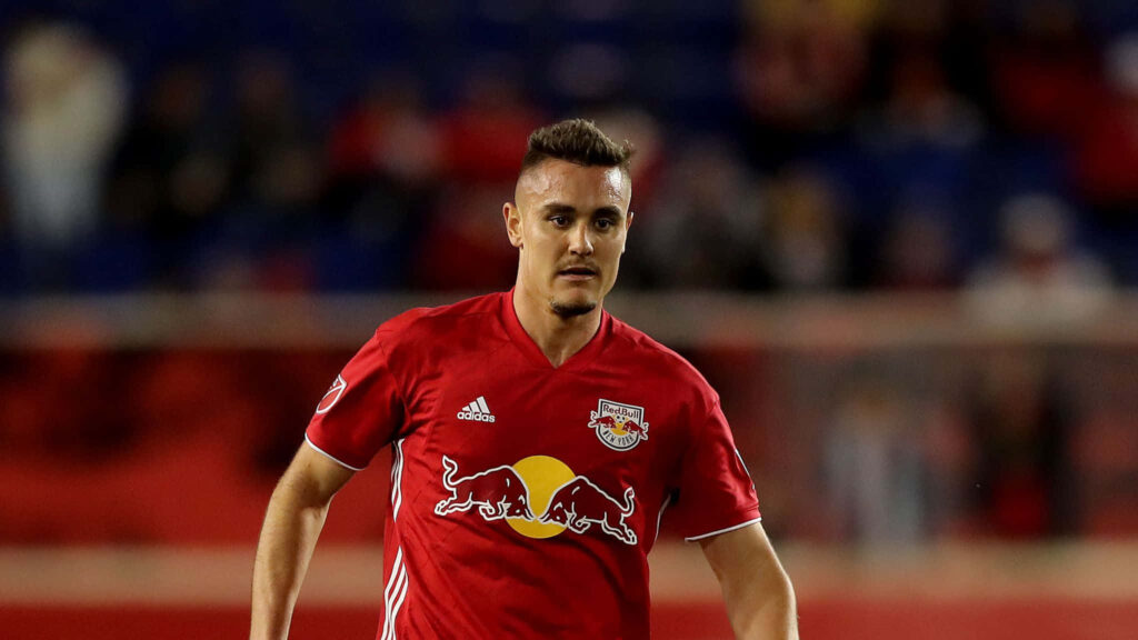 Aaron Long in red soccer kit focused during match against Minnesota United dynamic action shot Wallpaper
