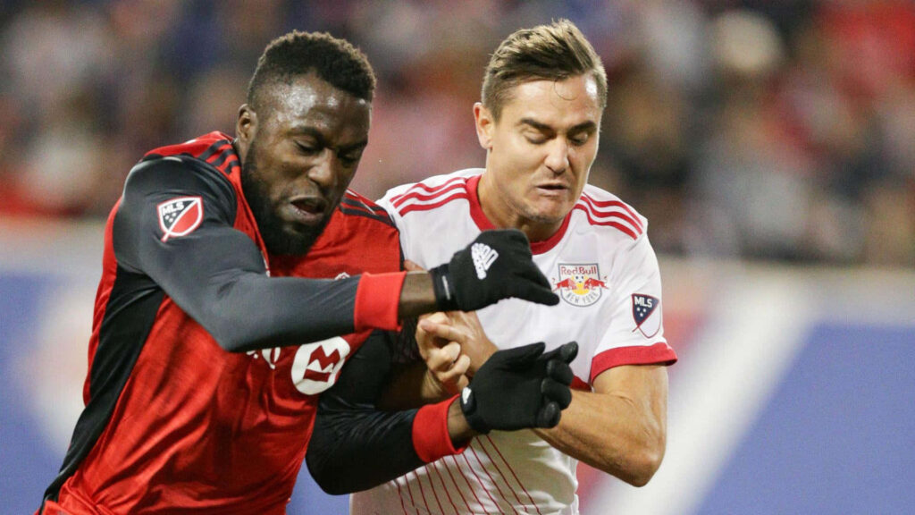 Soccer players Aaron Long and Jozy Altidore fiercely contest possession in intense match action Wallpaper