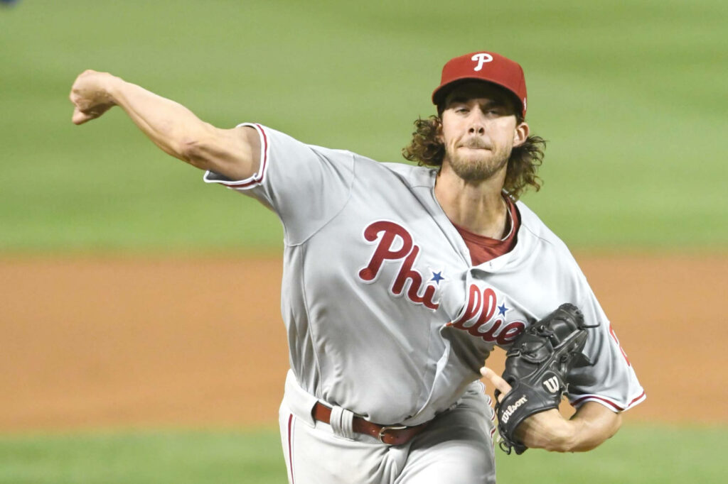 Aaron Nola pitching dynamically with a powerful throw in an intense baseball action wallpaper background
