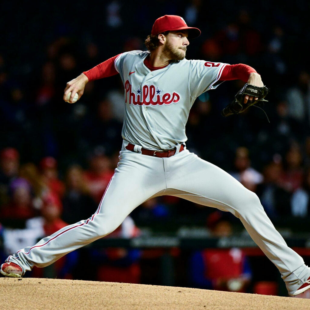 Aaron Nola pitching in Philadelphia Phillies uniform mid-throw intense focus baseball wallpaper