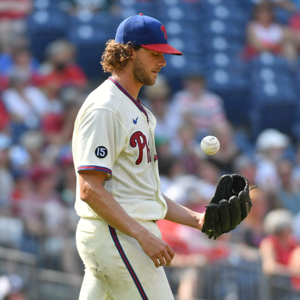 Aaron Nola Philadelphia Phillies tossing baseball on field focused game moment wallpaper background
