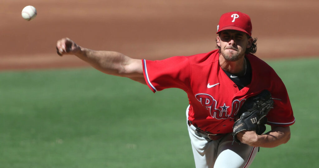 Aaron Nola pitching powerfully in Phillies uniform mid-throw on mound with intense focus Wallpaper