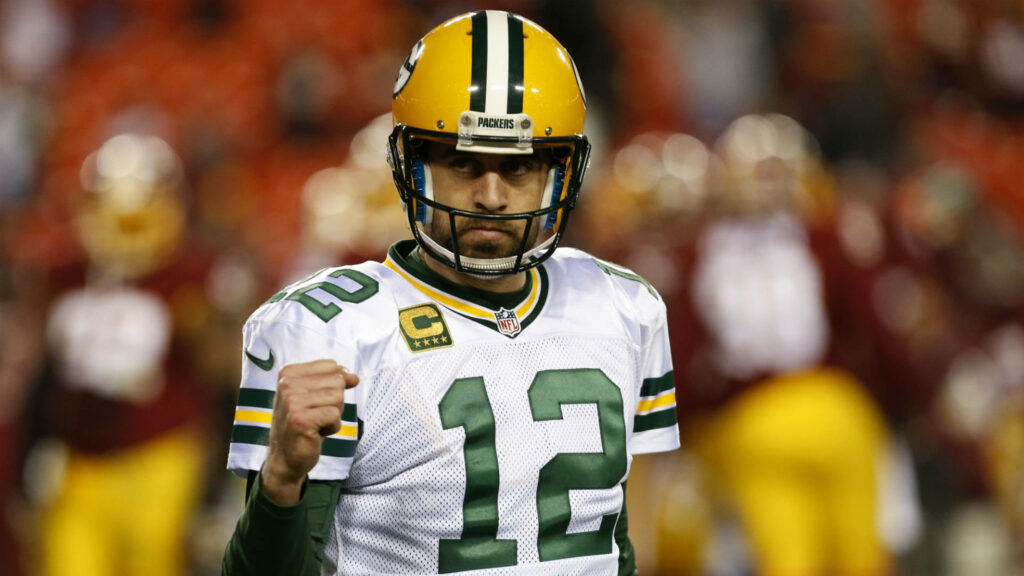 Aaron Rodgers Green Bay Packers quarterback in number 12 jersey focused on football field background Wallpaper