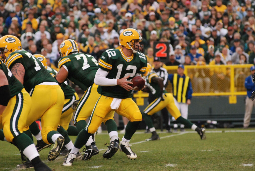 Aaron Rodgers focused in Green Bay Packers game ready to make a play on football field wallpaper