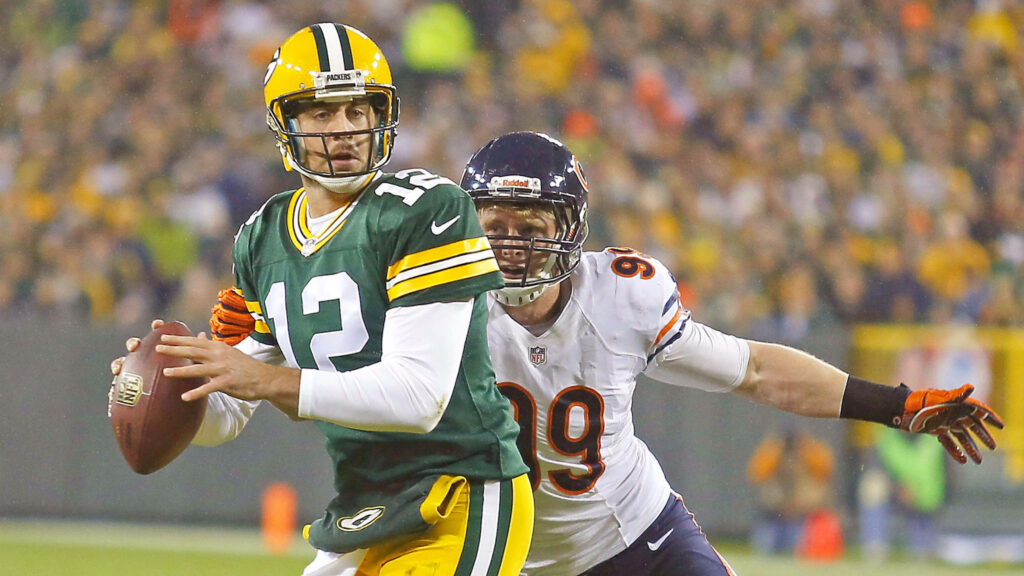 Aaron Rodgers preparing to pass in intense Green Bay Packers versus Chicago Bears football game action Wallpaper