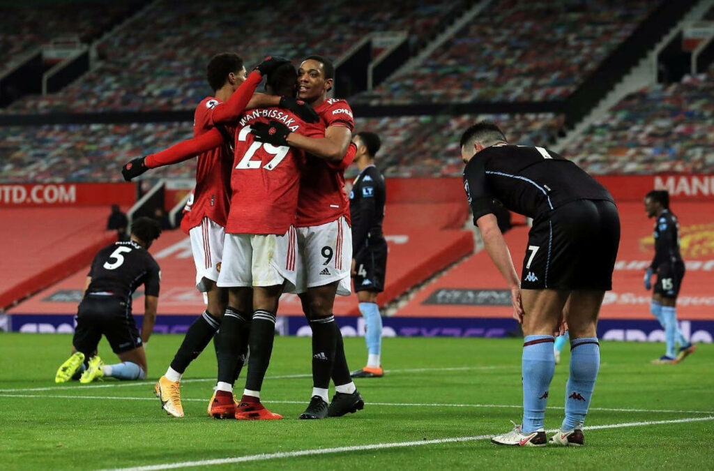 Aaron Wan-Bissaka celebrates victory with teammates in a joyful group hug on football field Wallpaper
