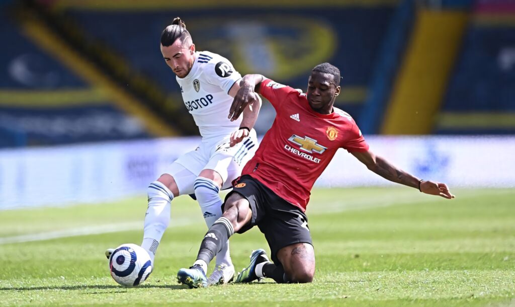 Aaron Wan-Bissaka sliding tackle showcasing defensive skill in intense Manchester United match wallpaper