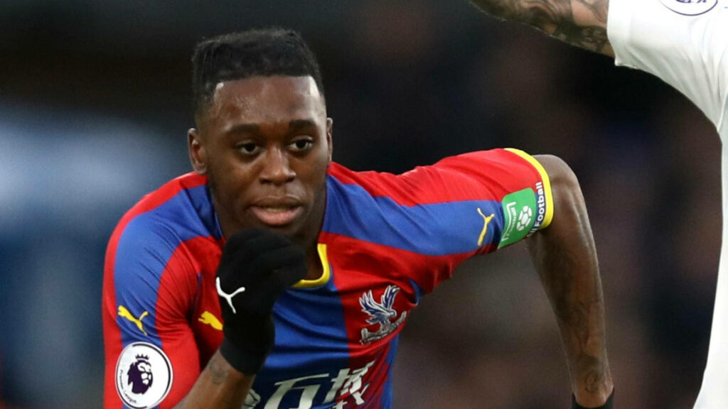 Aaron Wan-Bissaka running in Crystal Palace kit focused during Premier League match wallpaper