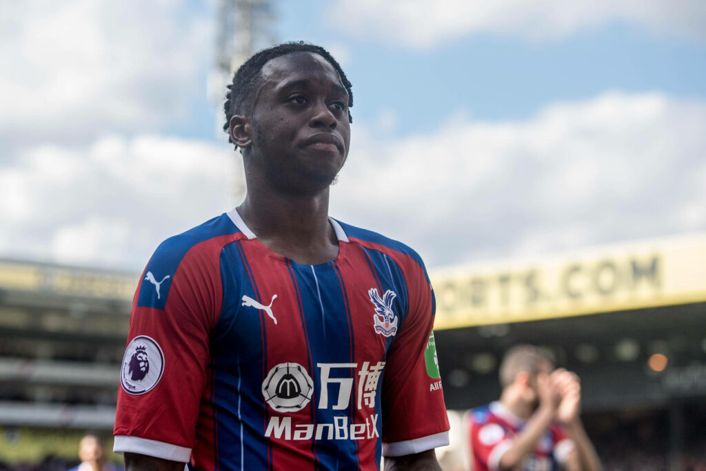 Aaron Wan-Bissaka in Crystal Palace kit focused on open field vibrant stadium background wallpaper