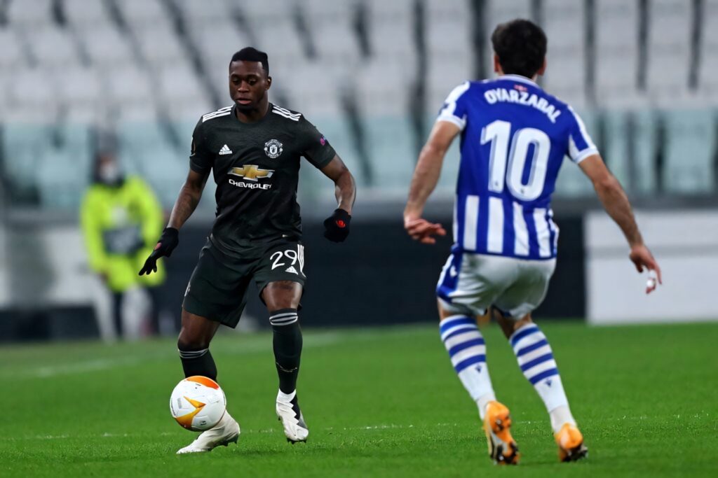 Aaron Wan-Bissaka evades opponent controlling ball displaying defensive agility in football match Wallpaper