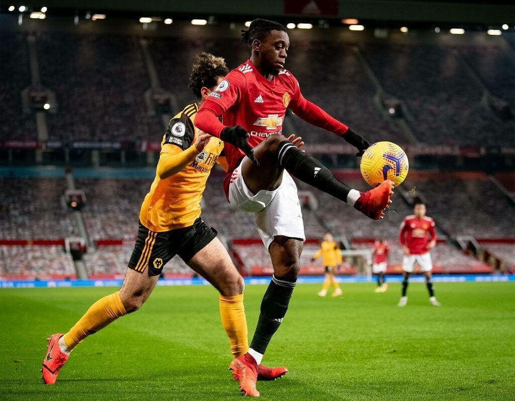 Aaron Wan-Bissaka controlling high ball showing defensive skills and agility in football match wallpaper