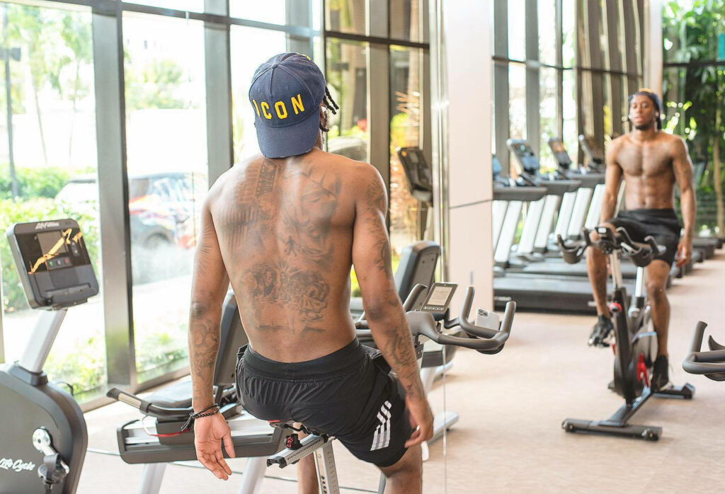 Aaron Wan-Bissaka intense cycling workout showing athletic build and focus in gym wallpaper
