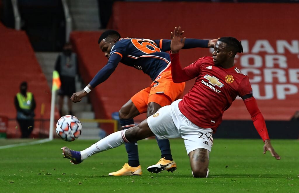 Aaron Wan-Bissaka executes precise sliding tackle showcasing defensive skills Manchester United match Wallpaper
