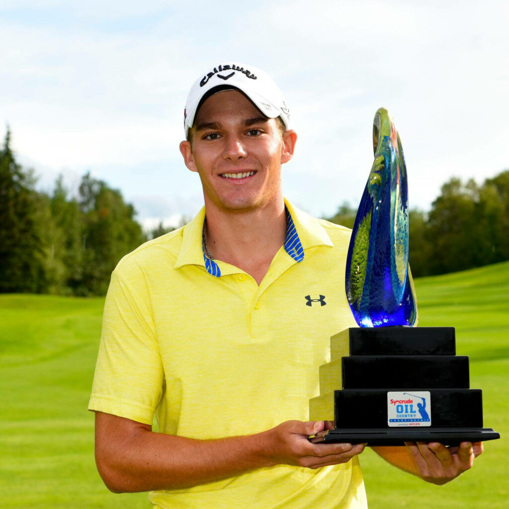 Aaron Wise smiling and holding modern golf trophy on vibrant green course celebrating win Wallpaper